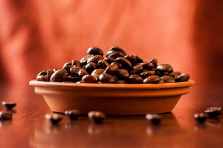 Background of ground coffee texture. Coffee beans are scon wooden table. attered on the table.の写真素材