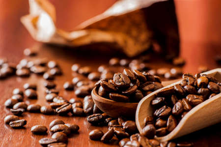 Background of ground coffee texture. Coffee beans are scon wooden table. attered on the table.Packaging for coffee.Closeup of coffee beans background.coffee beansの写真素材