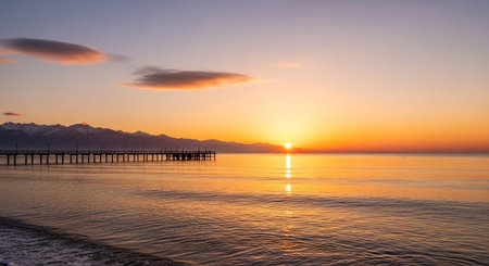 Sunset over the sea with a wooden pier in the foreground.の写真素材