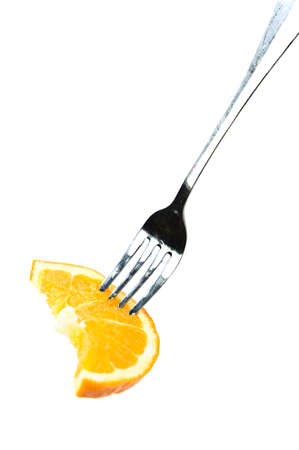 Slice of fresh orange on the forkの写真素材