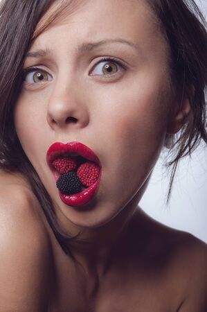 Girl with a candy in the mouthの写真素材