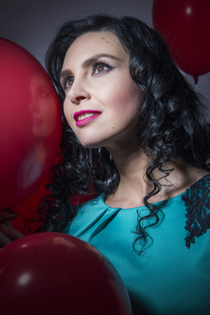 Happy young woman with red latex balloonsの写真素材