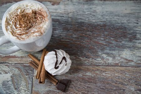 Hot coffee with marshmallows in a cup on the wooden backgroundの写真素材