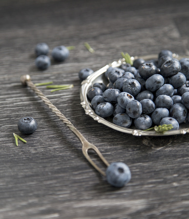 Blueberry in a plate on a wooden backgroundの写真素材