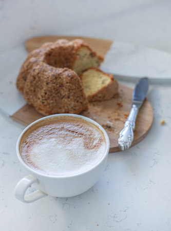 Cappuccino and cake on a white table, selective focusの写真素材