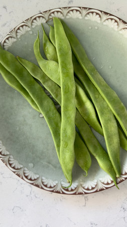 Fresh green string beans in a bowl on a marble tableの写真素材