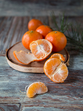 New Years Christmas still life: pine branch next to tangerine oranges on a wooden backgroundの写真素材