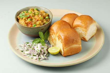 Pav Bhaji is a fast food dish from India, Thick and spicy vegetable curry, fried and served with a soft bread Bun Pav and butter. selective focusの写真素材