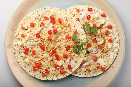masala papad, roasted urad daal papad with onion, tomato, sev and coriander toppingsの写真素材