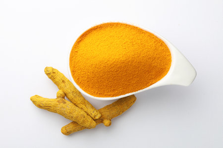 Turmeric powder in a bowl on white background. Top view.の写真素材