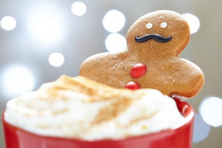 Gingerbread cookie men in a hot cup of cappuccino