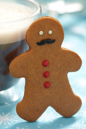 Gingerbread cookie men in a hot cup of cappuccino