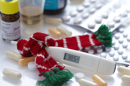 a fever thermometer and tablets. symbolic photo for flu and coldsの写真素材