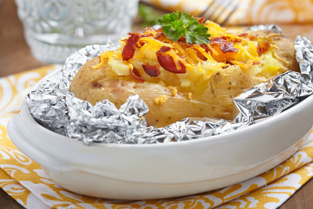 Baked potato with bacon, cheese, sour cream and onionの写真素材