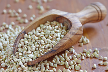 Green buckwheat grain in a wood scoopの写真素材