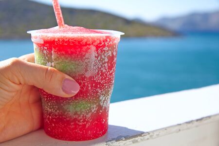 Frozen layered fruit drink in a woman handの写真素材