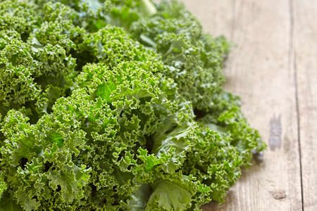 Fresh green kale leaves on wooden tableの写真素材