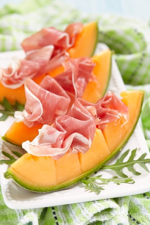 Fresh Cantaloupe Melon with Prosciutto and Arugulaの写真素材