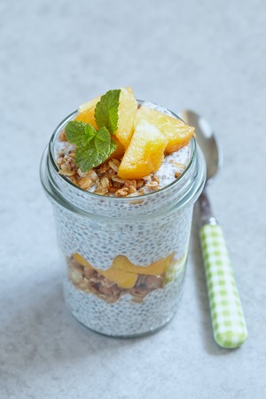 Chia pudding with peach and mango slices in a jarの写真素材