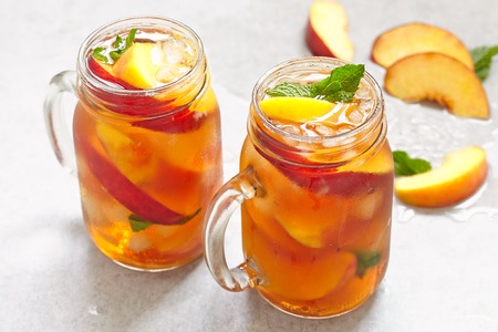 Mason jars of peach tea with iceの写真素材