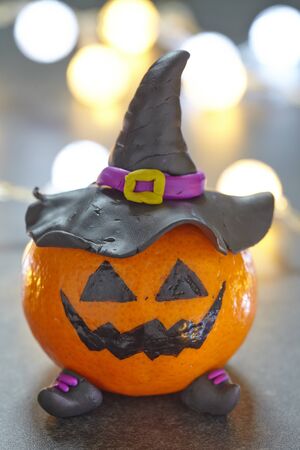 Funny Halloween pumpkin tangerine with black witches hatの写真素材