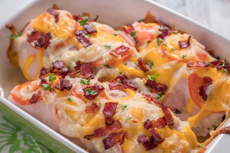Chicken breast roasted with cheese, bacon and tomatoesの写真素材