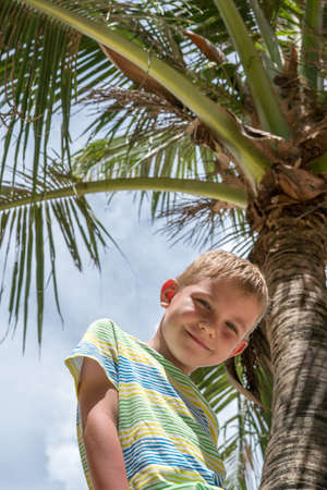 happy boy sitting on palmの写真素材