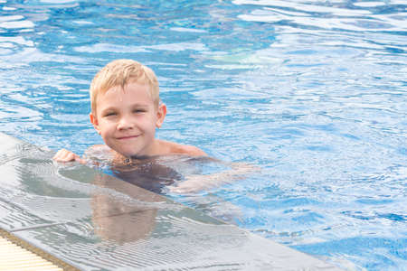 Boy swimming and playing in a pool