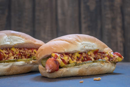 Grilled hot dogs with mustard, ketchup and dill picklesの写真素材