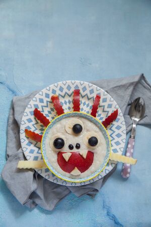 Kids breakfast funny oatmeal porridge monster with fruitsの写真素材