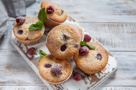 Baked Raspberry Muffins on a old white wooden tableの写真素材