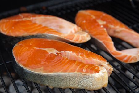 Salmon red fish steaks on the flaming grillの写真素材