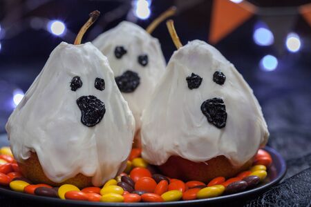 Halloween candy pears or white chocolate ghosts on a stickの写真素材