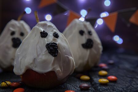 Halloween candy pears or white chocolate ghosts on a stickの写真素材