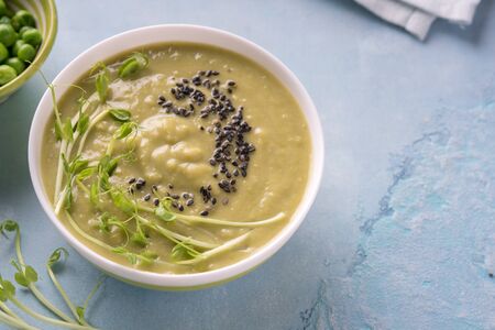 Green pea soup in bowl with black sesame seedの写真素材