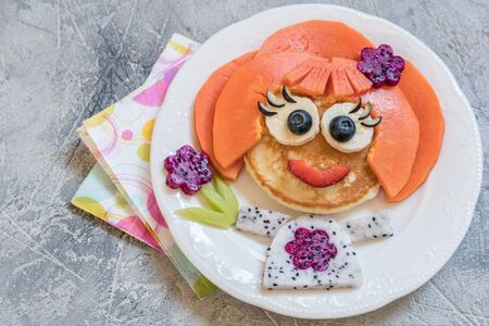 Funny girl pancake face with fruitsの写真素材