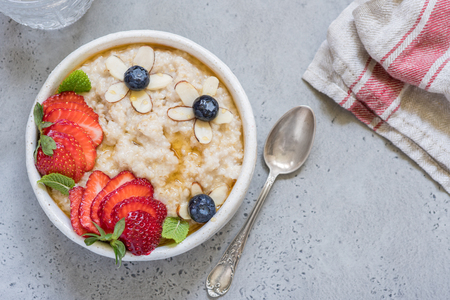 Steel cut oatmeal porridge with strawberry and blueberry for breakfastの写真素材