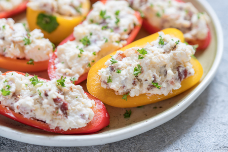 Colorful mini peppers stuffed with cheese, bacon and herbsの写真素材