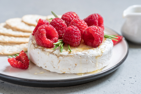 Baked Camembert cheese with raspberry and rosemaryの写真素材