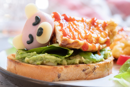 Sleeping bear. Toast with avocado, omelet and sausageの写真素材
