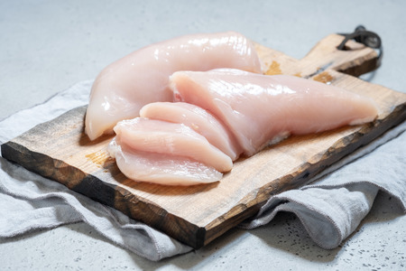 Fresh chicken meat on wooden boardの写真素材