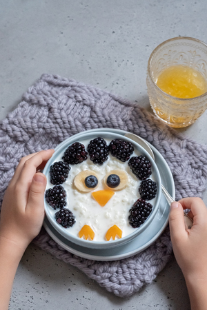 Funny kids breakfast porridge with berriesの写真素材