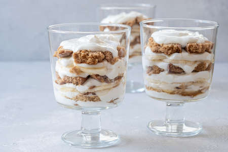 Banana caramel parfait trifle desserts with fresh whipped cream and chocolate cookie crumblesの写真素材