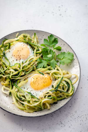 fried egg in zucchini noodle nestの写真素材