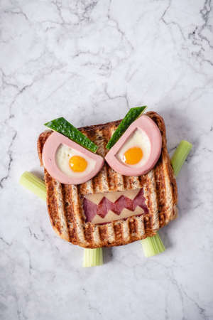 Monster sandwich with sausage, eggs and cheese on plate.の写真素材