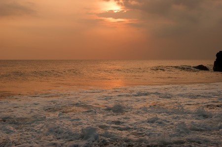 Sunset and kind at coast of Indian ocean about Tanah Lot Bali's ancient temple.の写真素材
