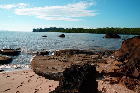 The blue sea of the stony coast which have grown with jungle of peninsula Santubong. Borneo.の写真素材