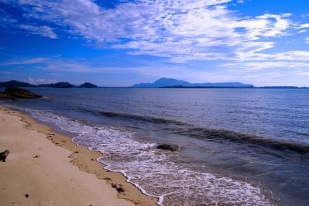 The blue sea of the stony coast which have grown with jungle of peninsula Santubong. Borneo.の写真素材