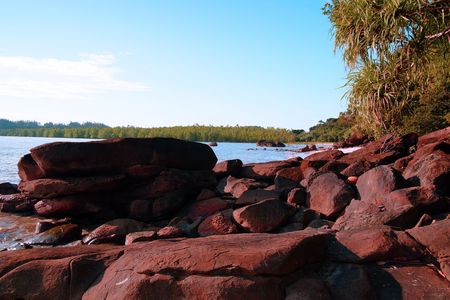 The blue sea of the stony coast which have grown with jungle of peninsula Santubong. Borneo.の写真素材