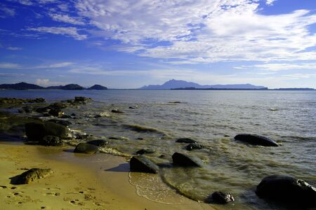 The blue sea of the stony coast which have grown with jungle of peninsula Santubong. Borneo.の写真素材